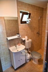a bathroom with a sink and a toilet and a mirror at Casa EBO in 2 Mai