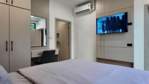 a bedroom with a bed and a tv on the wall at Zoha 2BR Private Pool Villa Bangtao in Thalang