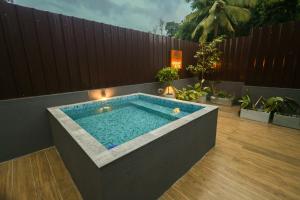 a swimming pool in a backyard with a wooden fence at Forest Face Lodge in Gurudeniya