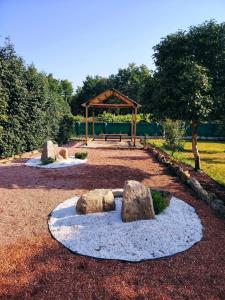 a park with rocks on the ground with a bench at As Cabanas DO RÍO PEGO in Santiago de Compostela