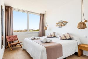 a bedroom with two beds and a window at VORAMAR by 3VILLAS in Cala en Forcat