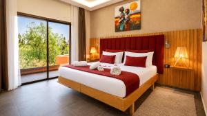 a bedroom with a large bed and a large window at Ourika Camp Suites Hotel & Resort in Marrakesh +34 photos
