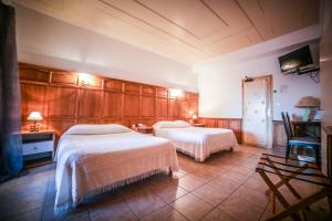 a hotel room with two beds and a tv at Castellu Rossu in Lucciana