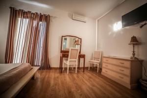a bedroom with a bed and a desk and a mirror at Castellu Rossu in Lucciana