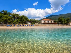 a beach with blue chairs in the water at Studios Plaka in Skala Kallirachis