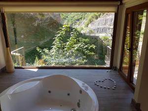 a bath tub in a bathroom with a large window at Hotel Puente Vidosa in Amieva +34 photos