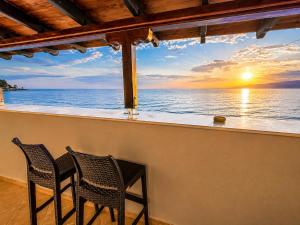 two chairs on a balcony with a view of the ocean at Studios Plaka in Skala Kallirachis +18 photos