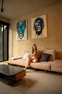 a woman sitting on a couch in a living room at Boga Mexico City by Lumina in Mexico City