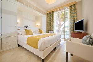 a bedroom with a large bed and a tv at Hotel Terme Marine Leopoldo II TERME & SPA in Marina di Grosseto