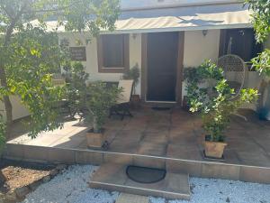 a courtyard with potted trees and a building at Anemolia Tiny Stone House in Palekastron
