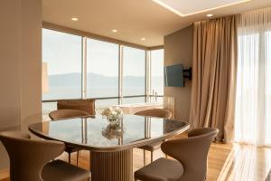 a dining room with a glass table and chairs at Kraal Hotel Vlore in Vlorë