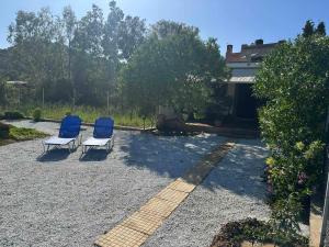 two blue and white chairs sitting in a yard at Anemolia Tiny Stone House in Palekastron