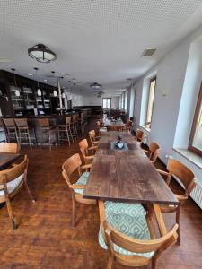 a dining room with wooden tables and chairs at Neros Hotel in Siegenburg