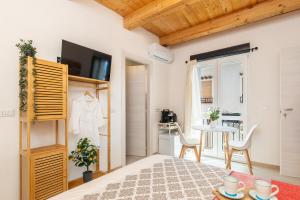 ein Schlafzimmer mit Bett und Tisch und eine Küche in der Unterkunft Tra Cale e Rioni in Baunei + 27 Fotos