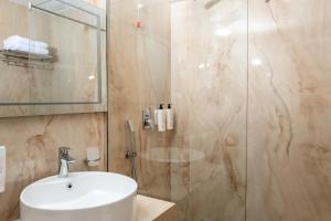 a bathroom with a sink and a glass shower at Kraal Hotel Vlore in Vlorë +98 photos