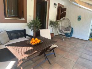 a bowl of oranges on a table on a patio at Anemolia Tiny Stone House in Palekastron