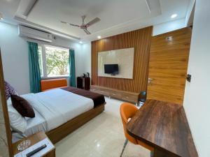 a bedroom with a bed and a table and a tv at Jayati Palace Hotel in Rudraprayāg