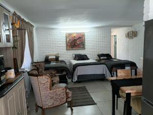 a bedroom with a large bed and a chair at Lourette se Plek in Sannieshof