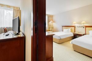a hotel room with two beds and a television at Occidental Paris Levallois in Levallois-Perret