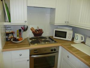a kitchen with a stove top oven next to a microwave at Salisbury Old Mill House in Salisbury