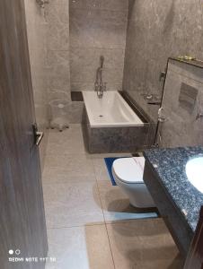 a bathroom with a tub and a toilet and a sink at Jayati Palace Hotel in Rudraprayāg