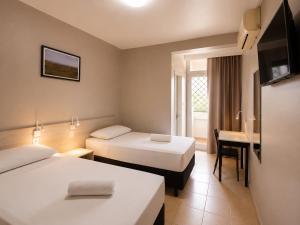a hotel room with two beds and a desk at Hotel El Pilar by Bsb Inn in Brasília +59 photos