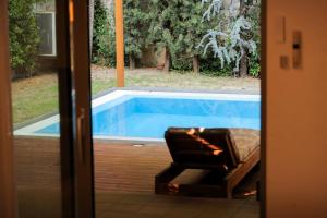 a chair sitting next to a swimming pool at Pool and Spa Retreat Villa in Tirana