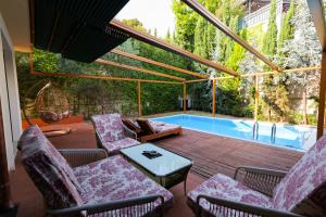 a patio with chairs and a table and a swimming pool at Pool and Spa Retreat Villa in Tirana