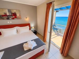 a bedroom with a bed and a view of the ocean at Studios Plaka in Skala Kallirachis