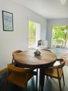 a wooden table and chairs in a living room at Forest Garden Retreat with Pool near the Beach in Seignosse