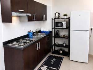 a kitchen with brown cabinets and a white refrigerator at Panoramic View, Cozy apartment M'diq in M'diq