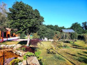 a tree in the middle of a yard with a pond at As Cabanas DO RÍO PEGO in Santiago de Compostela +92 photos