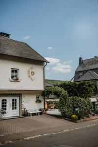 a white building with a bench in front of it at Ferienwohnung Haus Liane in Reil