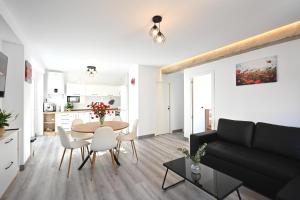 a living room and kitchen with a table and chairs at LEMON GARDEN Playa in Puerto de Sagunto