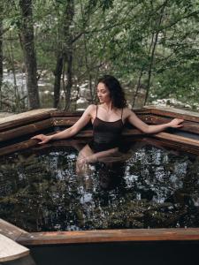 a woman is sitting in a tub of water at Будиночок між річками Гирло in Iltsi