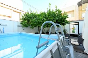 a swimming pool with a door in a building at LEMON GARDEN Playa in Puerto de Sagunto