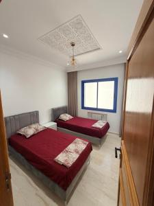 a bedroom with two beds and a window at Dar Carthage Hergla in Harqalah