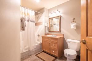 a bathroom with a toilet and a sink and a mirror at Copper Springs Lodge 301 in Copper Mountain