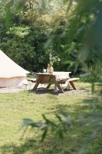 a picnic table in a field with a vase on it at Smuk Grutte Bell Tent nabij het water in Friesland in Echtenerbrug