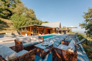 an outdoor patio with a couch and chairs next to a pool at La VILLA DU REVE in Ulcinj