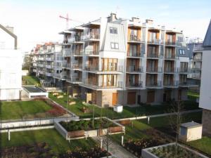 a large apartment building with a yard in front of it at Trzy Wyspy Apartments - Aquamarina in Świnoujście