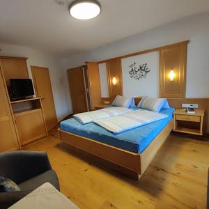 a bedroom with a large bed with blue sheets at Pretzners Ferienwohnungen in Reit im Winkl