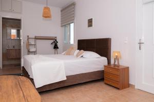 a bedroom with a large bed and a night stand at Theahouse in Pythagoreio +19 photos