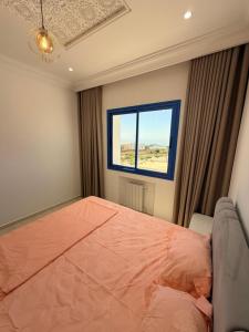 a bedroom with a large bed and a window at Dar Carthage Hergla in Harqalah