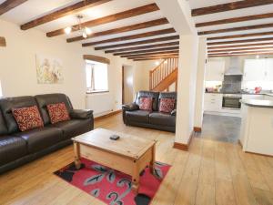 a living room with a couch and a coffee table at Stabal-y-Gwedd in Llanddulas