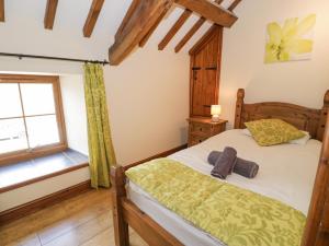a bedroom with a bed and a window at Stabal-y-Gwedd in Llanddulas