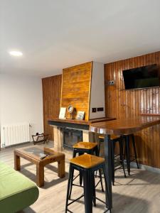 a room with a wooden wall with a table and stool at El Rincón De Tere in Riaza