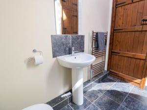a bathroom with a white sink and a toilet at Stabal-y-Gwedd in Llanddulas +23 photos