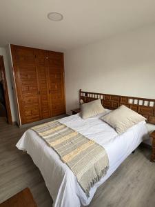 a bedroom with a large bed with white sheets and pillows at El Rincón De Tere in Riaza