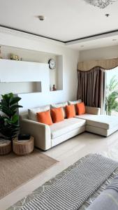 a living room with a white couch and orange pillows at View Talay 7 Seaview Apartments in Pattaya South